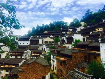 Houses in town against cloudy sky