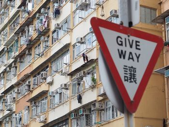 Low angle view of road sign against built structures