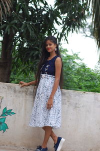 Full length of woman standing against tree