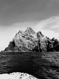 Rock formations by sea against sky
