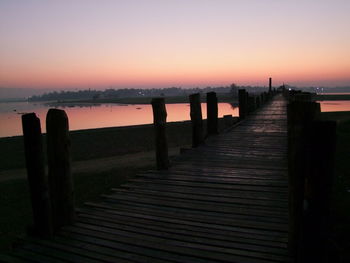 Pier over sea against sky during sunset