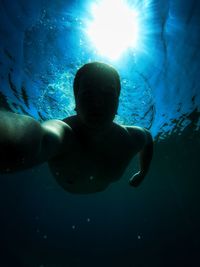 Low angle view of shirtless man swimming in sea