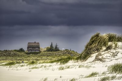 Scenic view of  dune against dark sky