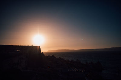 Scenic view of sea against clear sky during sunset