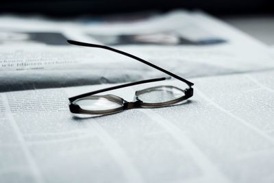 Close-up of eyeglasses on newspaper