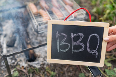 The inscription barbecue on a black plate, fire on the background of the grill grate