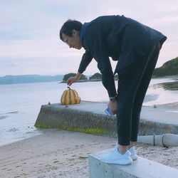 Man standing at beach against sky