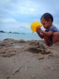 Boy on beach against sky