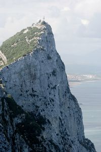 Scenic view of mountain by sea against sky