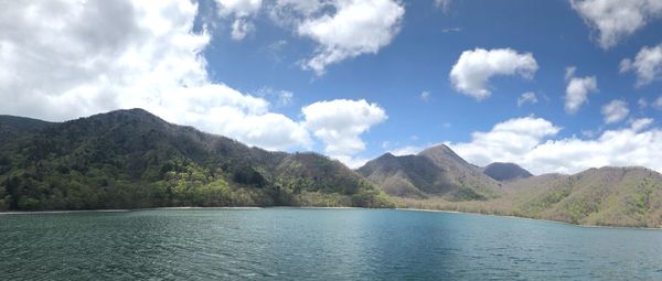 Scenic view of sea and mountains against sky