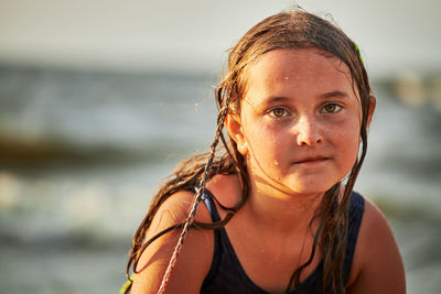 Portrait of young woman standing at beach