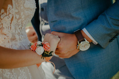 Midsection of couple holding hands