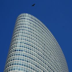 Low angle view of modern office building against clear blue sky