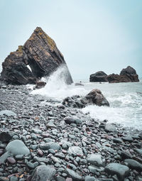 Rocks in sea against clear sky