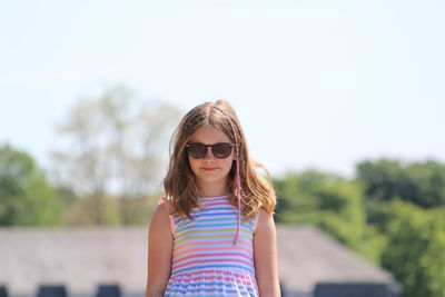 Portrait of girl wearing sunglasses while standing against sky