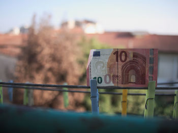 Close-up of text on metal against sky