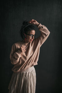 Midsection of woman standing against black background