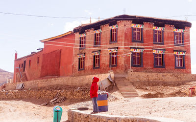 Side view of woman standing against building