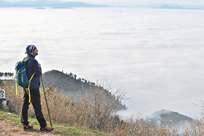 Rear view of hiker standing on top of mountain 