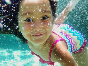 Portrait of young woman swimming in swimming pool