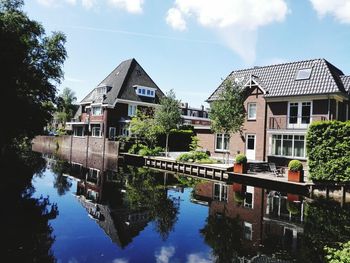 Reflection of buildings in lake against sky