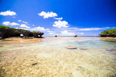 Scenic view of beach against blue sky