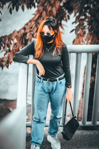 Full length of young woman wearing sunglasses standing outdoors