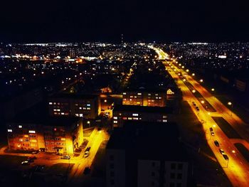 Illuminated cityscape against sky at night