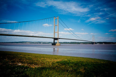 Bridge over river against cloudy sky