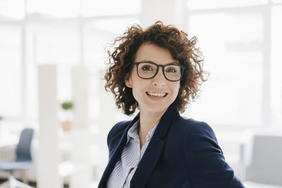 Businesswoman standing in her office, smiling