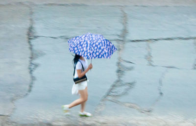 Woman with umbrella walking in rain