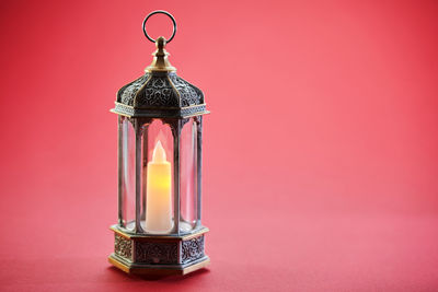 Close-up of illuminated lamp against wall