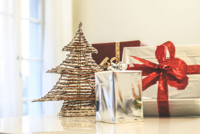 Gift boxes near christmas tree inside home. box with holiday ribbon with bows. festive atmosphere