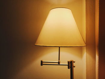 Close-up of lamp against wall at home