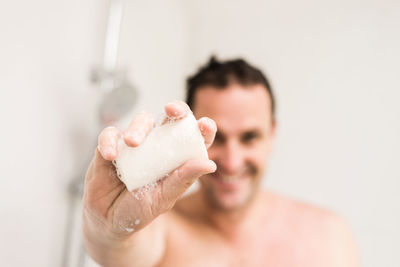 Close-up portrait of man holding soap