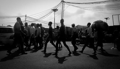 People on bridge against sky in city