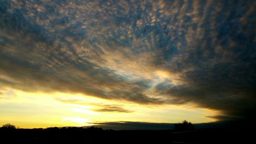 Silhouette of landscape against cloudy sky