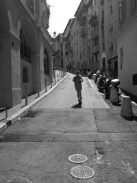 Man walking on street amidst buildings in city