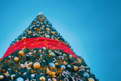 Low angle view of christmas tree against blue sky