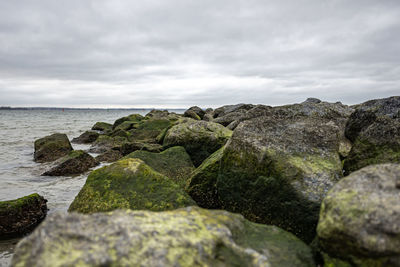 Rocks on sea shore against sky