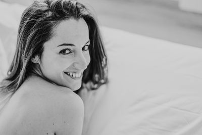 Portrait of smiling woman lying on bed