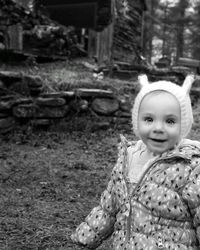 Portrait of cute baby girl standing in forest during winter
