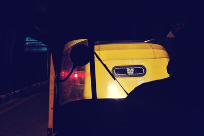 Close-up of yellow car on illuminated street at night