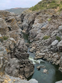 Rocks on river by rock formation