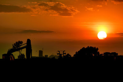 Silhouette trees against orange sky during sunset