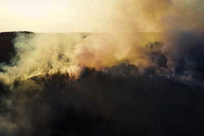 Smoke emitting from clouds against sky