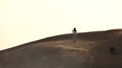 Man in desert against clear sky