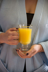 Midsection of woman holding juice in glass