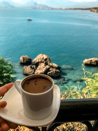 Coffee cup on table by sea