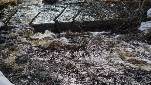 Frozen river flowing through rocks